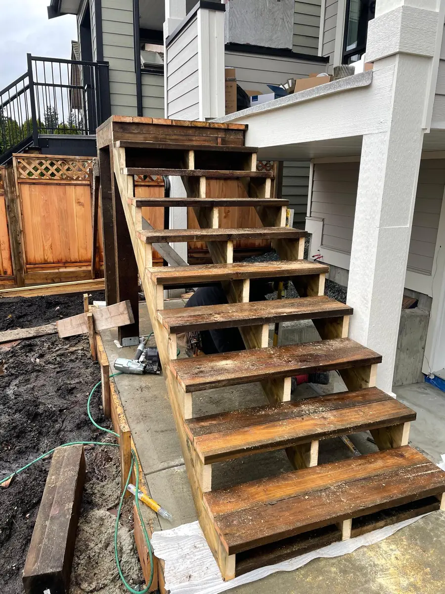 A wooden exterior staircase framed on site with stringers and treads in place